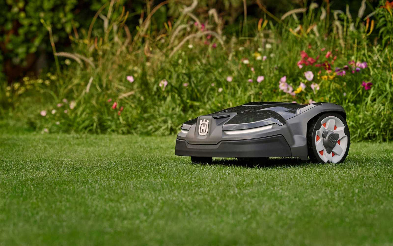Husqvarna Automower cutting the grass with bright flowers in the background. 